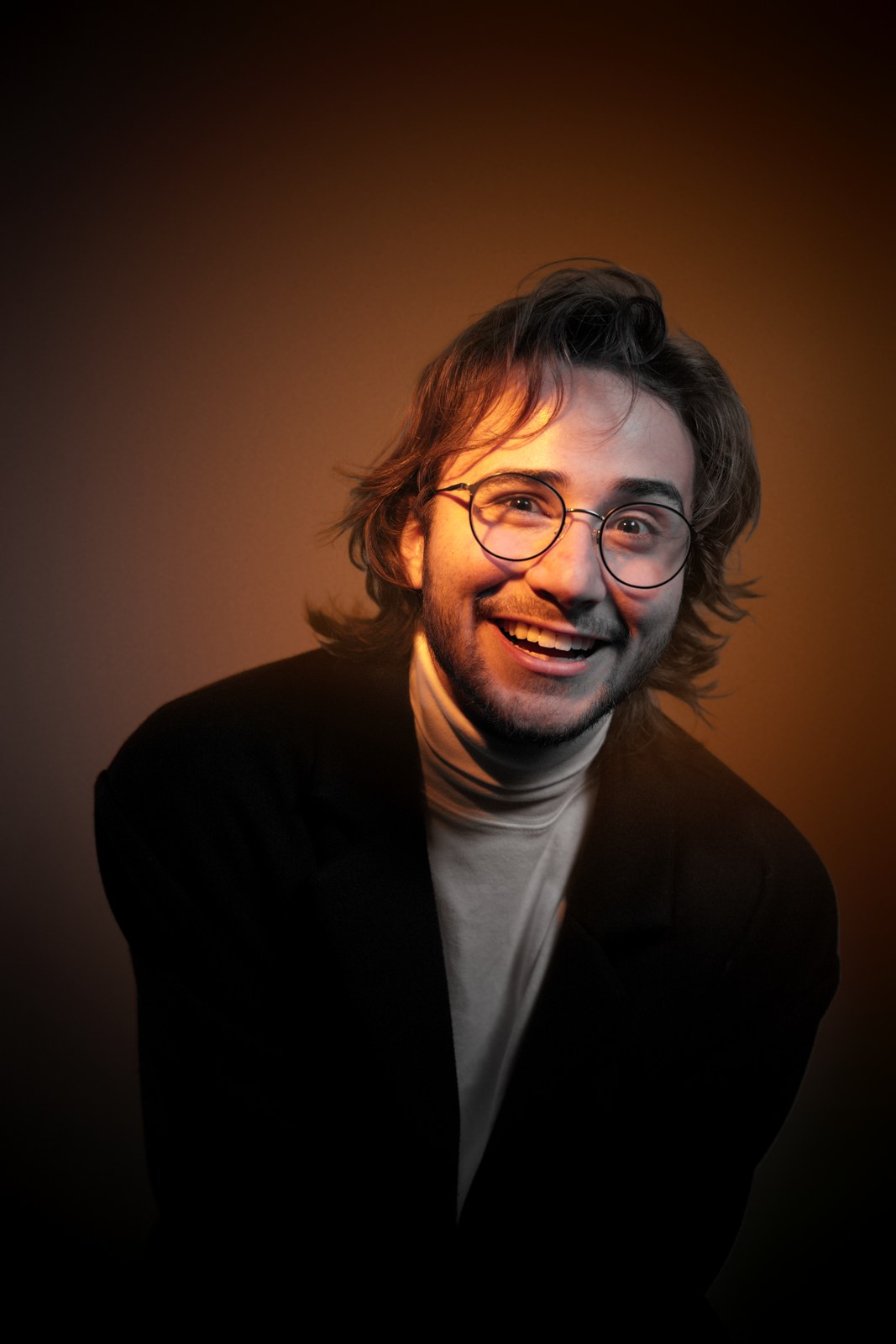 Smiling portrait in warm orange light.