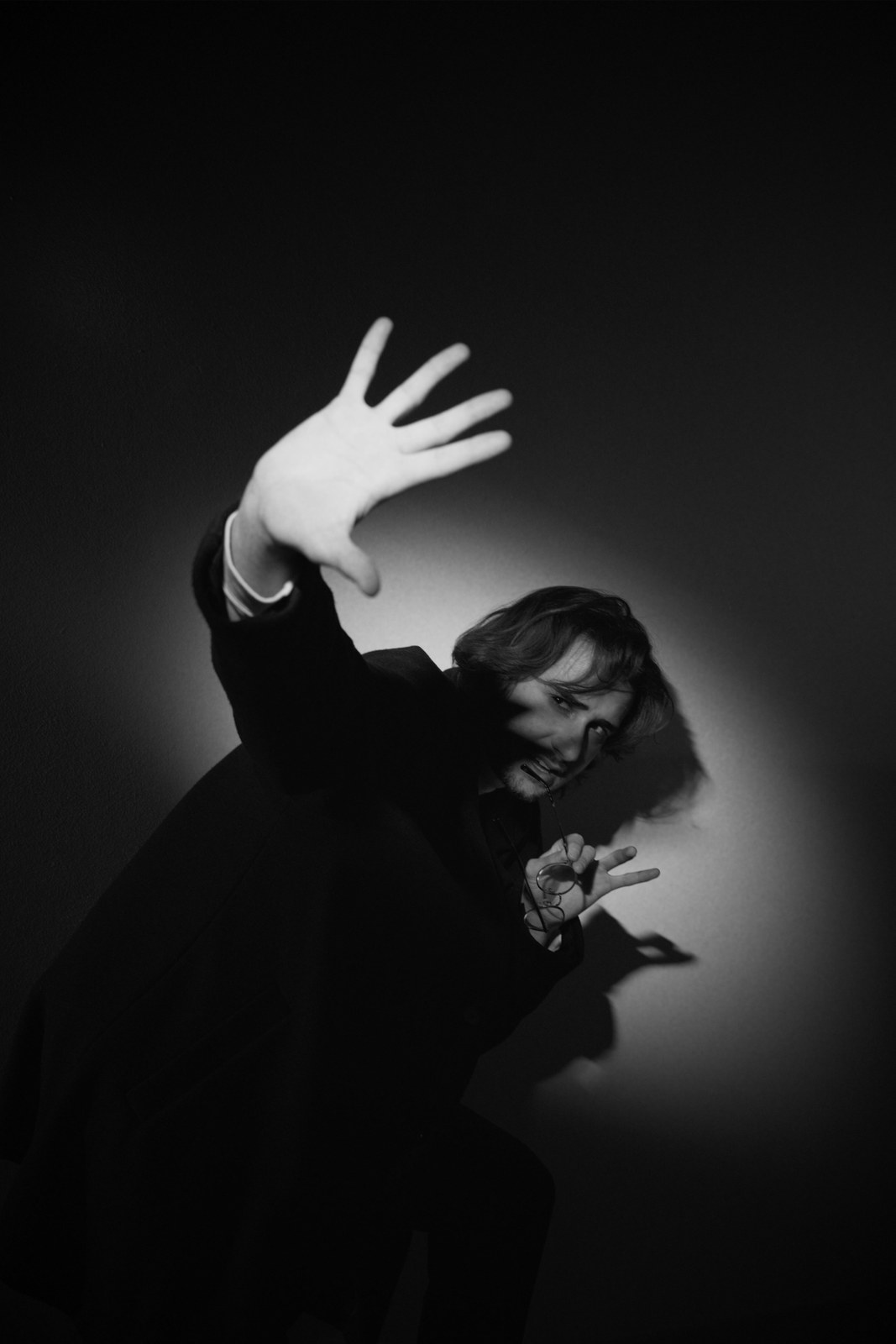 Black-and-white portrait with an arm lifted above the head.